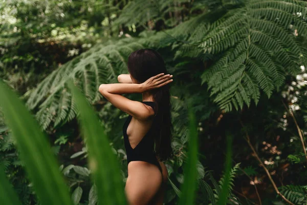 Jeune femme attrayante parmi les plantes tropicales. — Photo