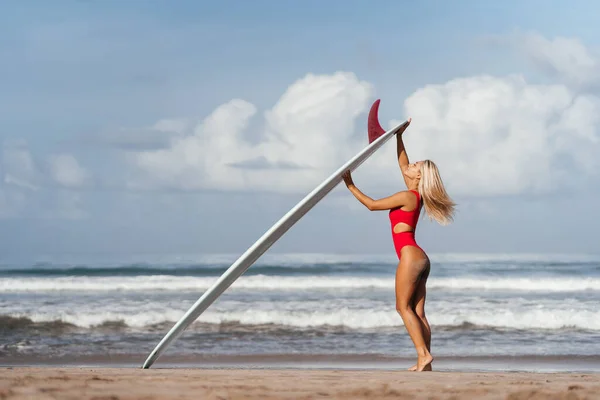 Surf kvinna med långt blont hår gå till havet. — Stockfoto