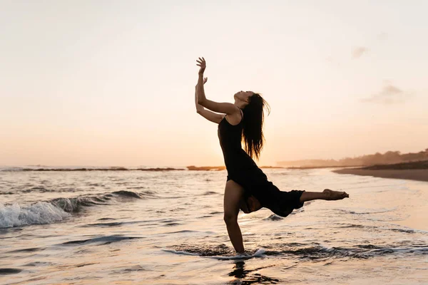 Libertad Mujer china sintiéndose libre bailando al atardecer en la playa. —  Fotos de Stock