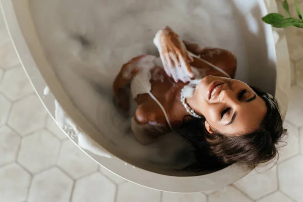 Jeune femme détendue allongée dans la baignoire — Photo