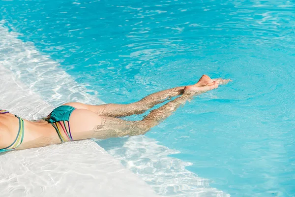 Belle femme jambes éclaboussures dans la piscine — Photo