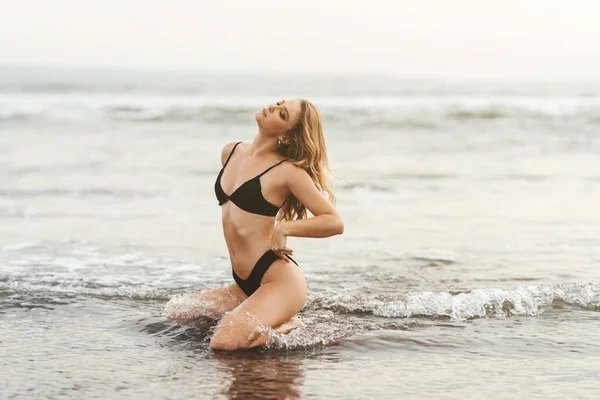 Ung kvinna njuter av solig dag på tropisk strand — Stockfoto