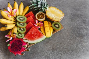Tahta tabakta tropik meyve çeşitleri. Taş arkaplan.