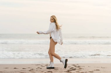 Genç bayan tropikal sahilde güneşli bir günün tadını çıkarıyor.