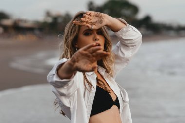 Genç bayan tropikal sahilde güneşli bir günün tadını çıkarıyor.