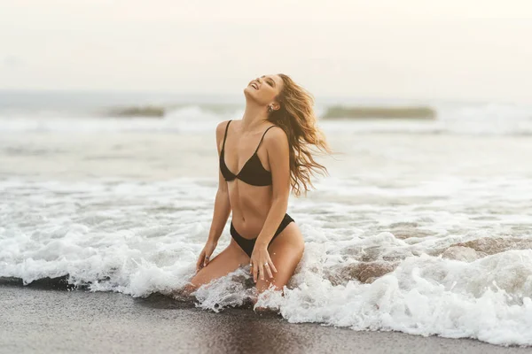 Ung kvinna njuter av solig dag på tropisk strand — Stockfoto