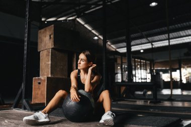 Koyu gri arka planda uygun bir şekilde formda genç bir kadın..