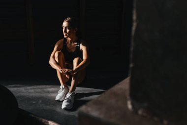 Koyu gri arka planda uygun bir şekilde formda genç bir kadın..