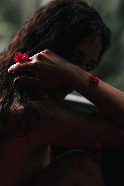 Küvette gül yapraklı güzel bir kadın. Vücut bakımı.