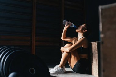 Koyu gri arka planda uygun bir şekilde formda genç bir kadın..