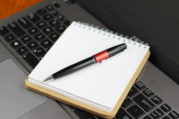 Diario bianco con penna con computer portatile su un tavolo di legno Foto Stock Royalty Free