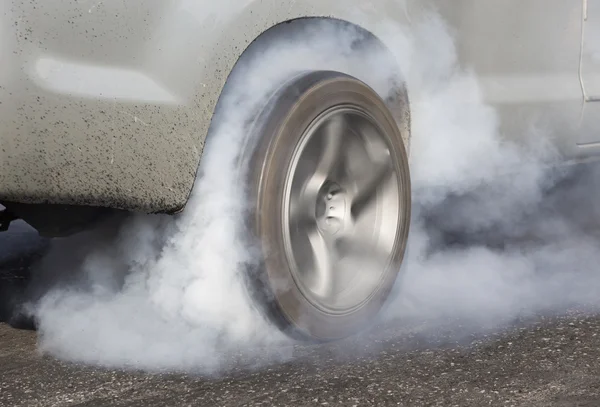 Drag racing samochód pali gumy off jego opony. — Zdjęcie stockowe