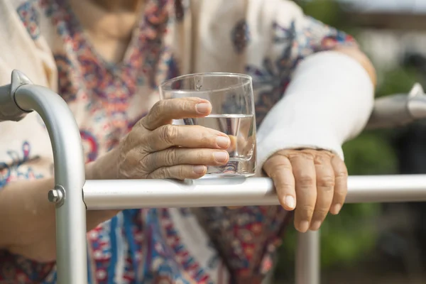 Senior woman broken wrist using walker in backyard. — Stock Photo, Image