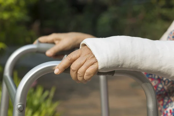 Senior woman broken wrist using walker in backyard. — Stock Photo, Image