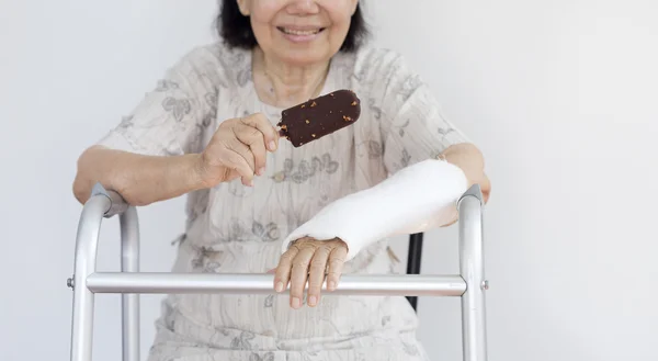 Anciana rota muñeca disfrutando de helado —  Fotos de Stock