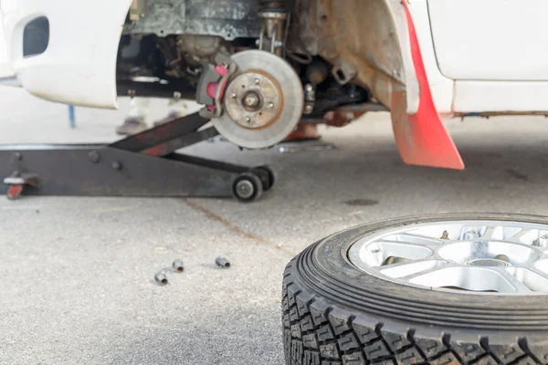 Cambiare un pneumatico su un'auto da rally nell'area di manutenzione — Foto Stock