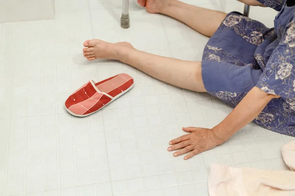 Пожилая женщина падает в ванной комнате (фокус под рукой ) — стоковое фото