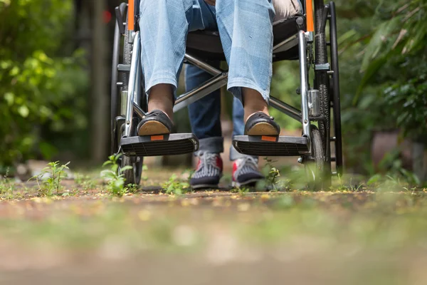 老妇在轮椅行走与照顾者 — 图库照片