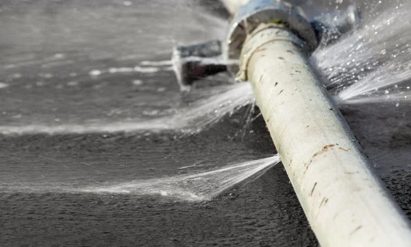 Wasser tritt aus Loch in Schlauch aus — Stockfoto