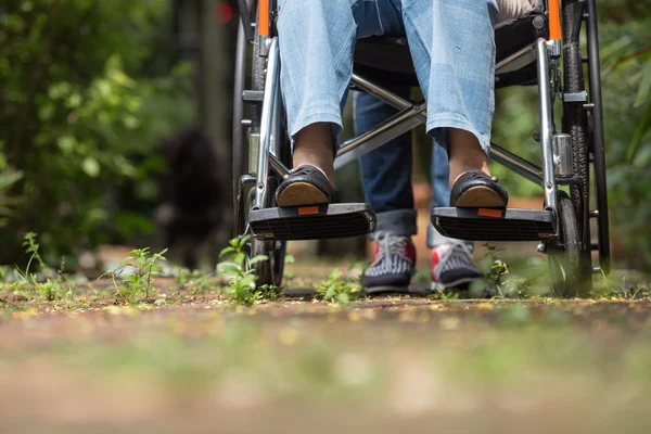 Starsza kobieta na wózku inwalidzkim, chodzenie z samochodu — Zdjęcie stockowe