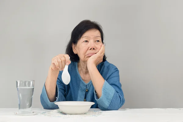 Anciano asiático mujer aburrido con comida —  Fotos de Stock