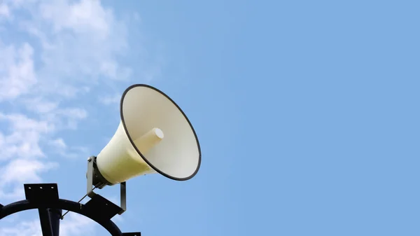 Loudspeakers on blue sky in park — Stock Photo, Image