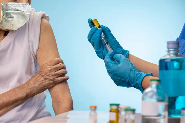为老年妇女注射疫苗的产科病房护士 — 图库照片