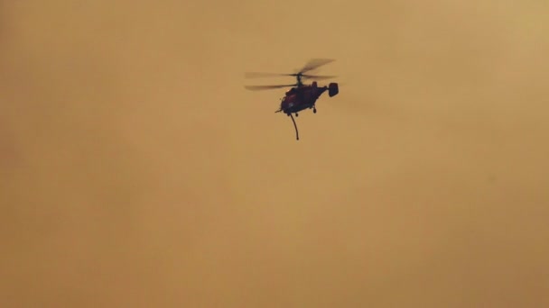 Silueta Elicopterul Luptă Împotriva Incendiilor Transportă Apă Pentru Stingerea Focului — Videoclip de stoc