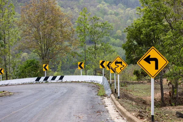 Road Sign Caution Indicating Left Turn Danger Slippery Road Mountain — Stock Photo, Image