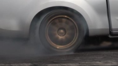 Yarış pistinde kalkış çizgisinde yarış arabasının lastiği yanıyor.