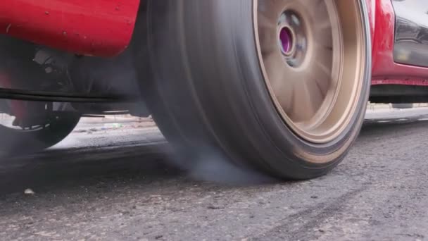 レーストラックでスタートラインでレースカー燃焼タイヤをドラッグ — ストック動画