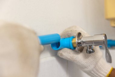 İşçi eski banyonun duvarına yüzen boru hattı kuruyor.