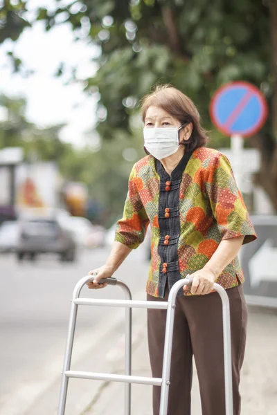 Oudere chinese vrouw dragen masker voor beveiligen luchtverontreiniging . — Stockfoto