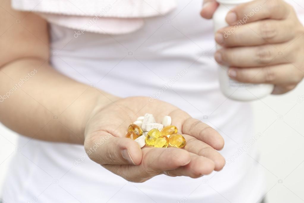 Woman hand with Cod liver oil and supplements