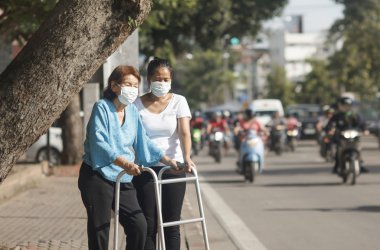 yaşlı kadın maskeyle koru hava kirliliğinin için şehir merkezinde