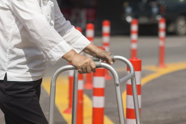 Seniorin überquert Straße mit Rollator. — Stockfoto