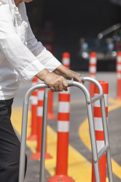 Senior vrouw met behulp van een walker cross street. — Stockfoto