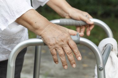 kadın kıdemli bir walker kullanarak çapraz sokak