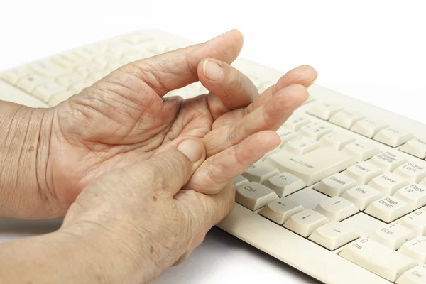 Старшая женщина болезненный палец из-за длительного использования клавиатуры — стоковое фото