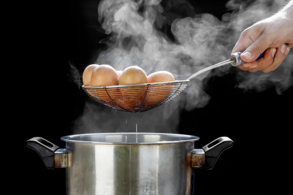 Koken eieren in roestvrij staal pot — Stockfoto