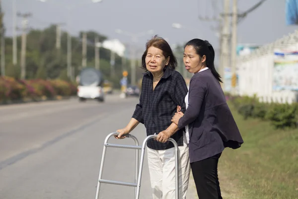 Mulher sênior usando um andador cruzar rua — Fotografia de Stock