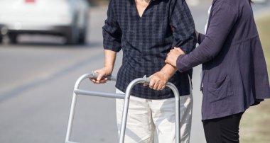 kadın kıdemli bir walker kullanarak çapraz sokak
