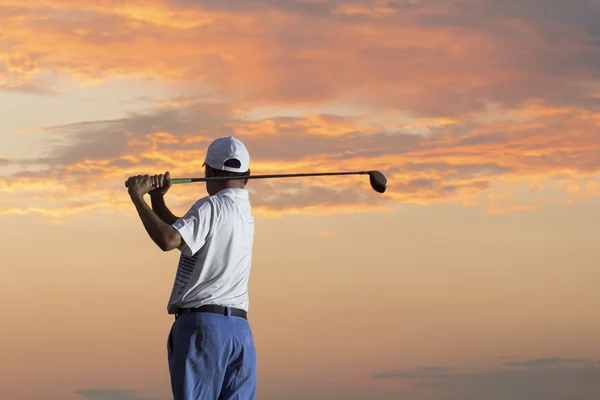 Man spelar golf mot solnedgången — Stockfoto