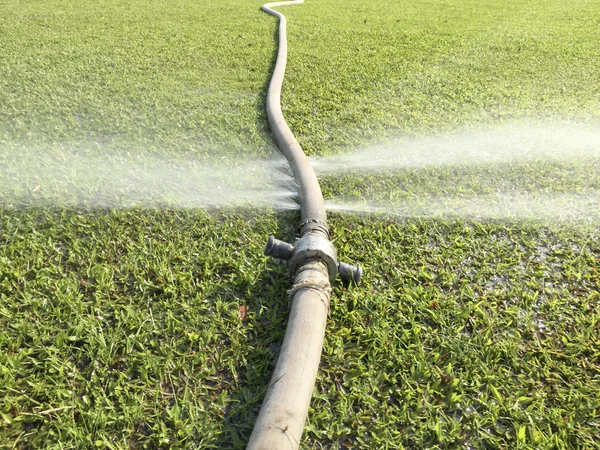 Wasser verschwenden - Wasser, das aus einem Loch in einem Schlauch austritt — Stockfoto