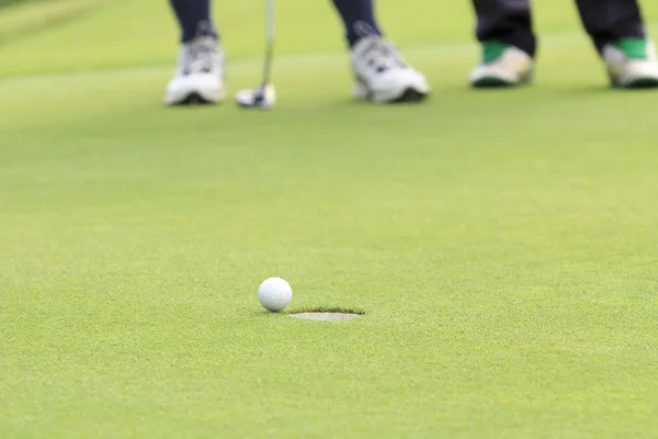 Golf ball on the edge of hole — Stock Photo, Image
