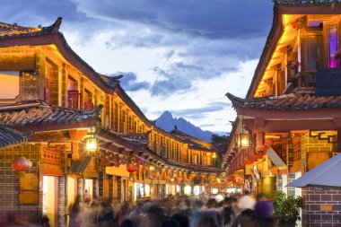 Akşam Lijiang 'ın eski kasabasında kargalı bir turist vardı..