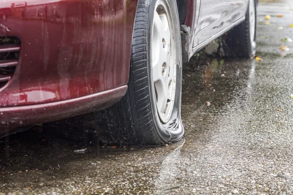 Pneumatico piatto auto in giorno di pioggia — Foto Stock