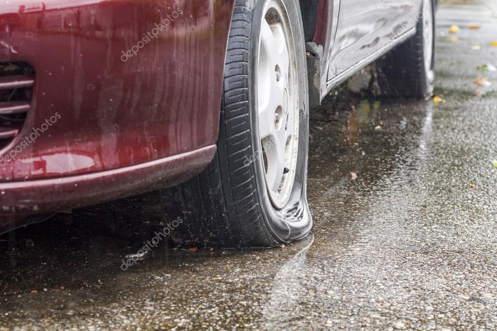 Car flat tire in rainy day Stock Photo by ©toa55 77540732