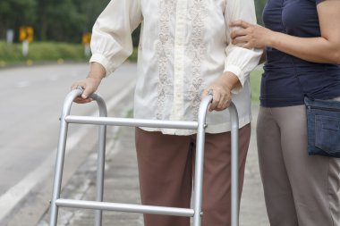 kadın kıdemli bir walker kullanarak çapraz sokak