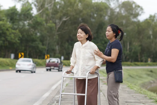 Mujer mayor usando un andador de la calle cruzada —  Fotos de Stock